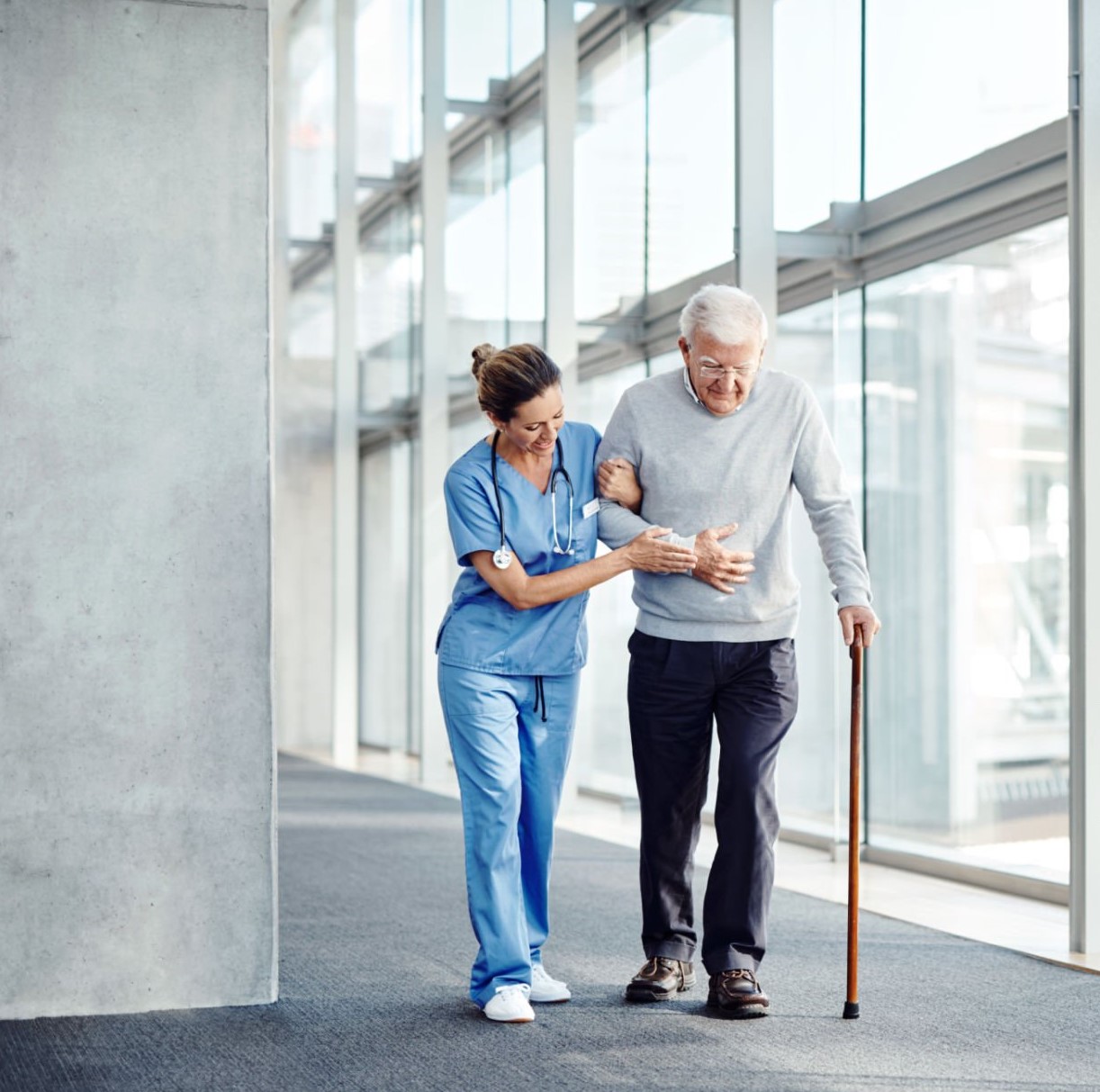médecin aidant une personne âgée à se déplacer.
